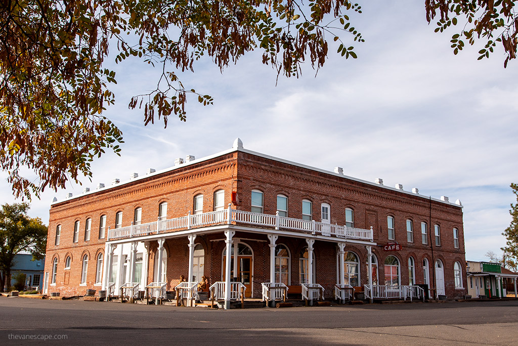 Shaniko Hotel made from red bricks with white ornaments in the front.