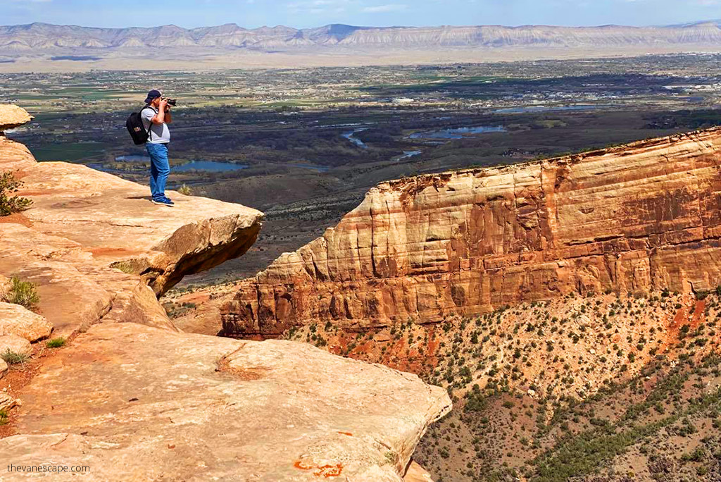Chris Labanowski, co-founder of the blog, is standing on the enge of the rock and is taking pictures from one of best viewpoints in the Colorado National Monument.
