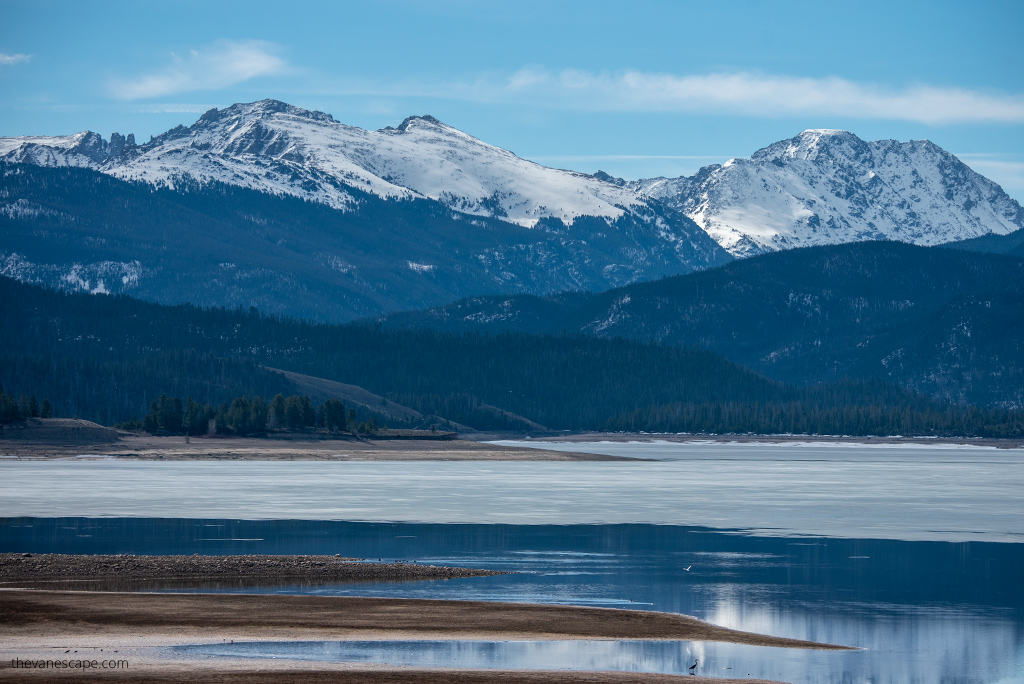 The morning view of the Grad Lake with Rocky Mountains peaks covered by snow. 