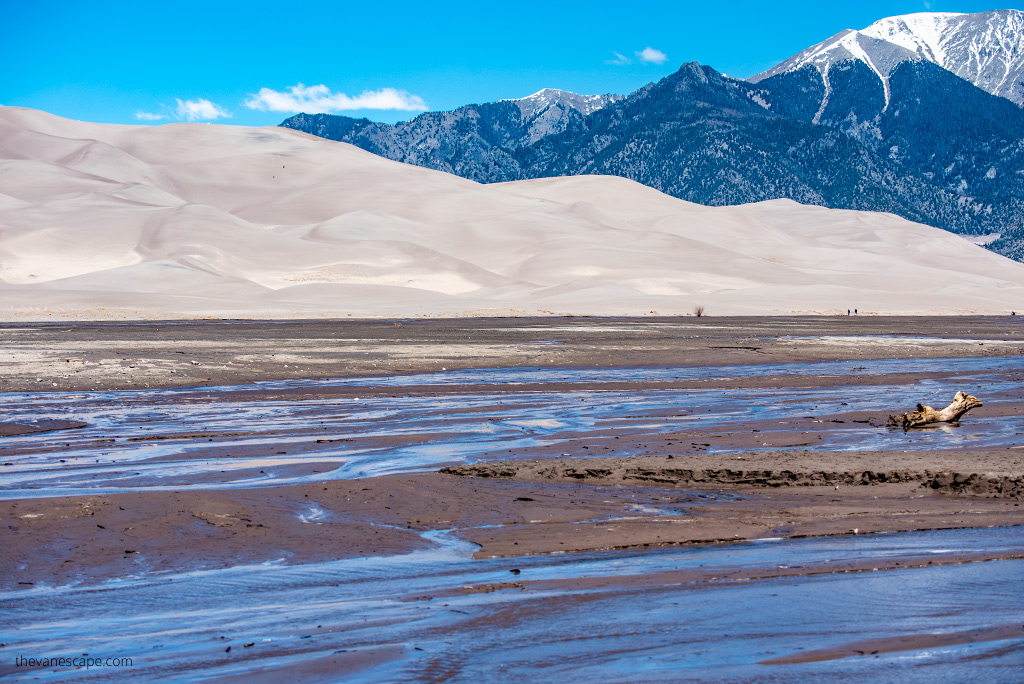 Medano Creek with dunes and mountains in the backdrop.