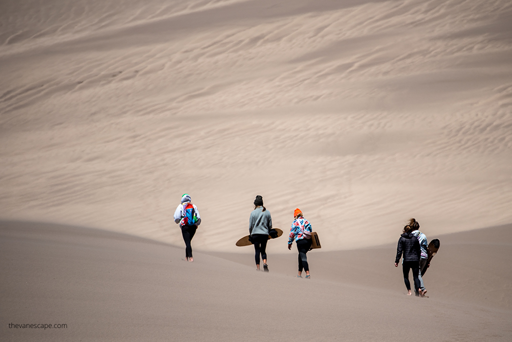 Youth with snowbords In Great Sand Dunes National Park.