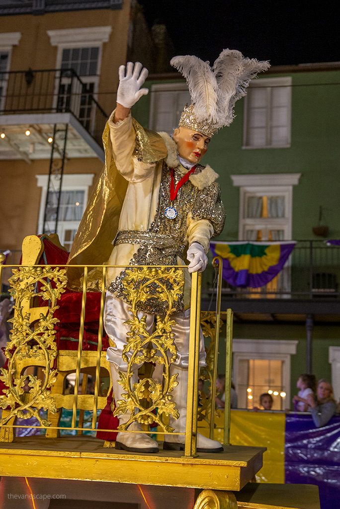 Mardi Gras in New Orleans man in a gold costium on the platform.