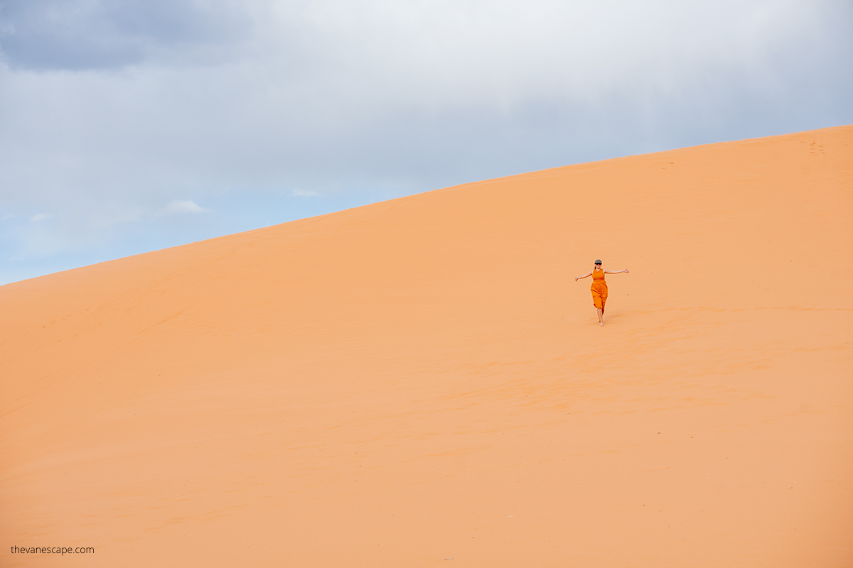 Agnes Stabinska, the author, in orange dress in Coral Pink Sand Dunes.