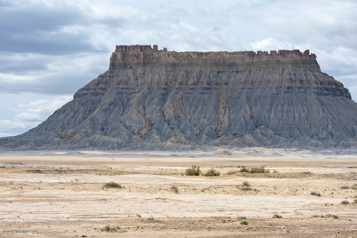 Huge and high Factory Butte surrounded by flat surface.