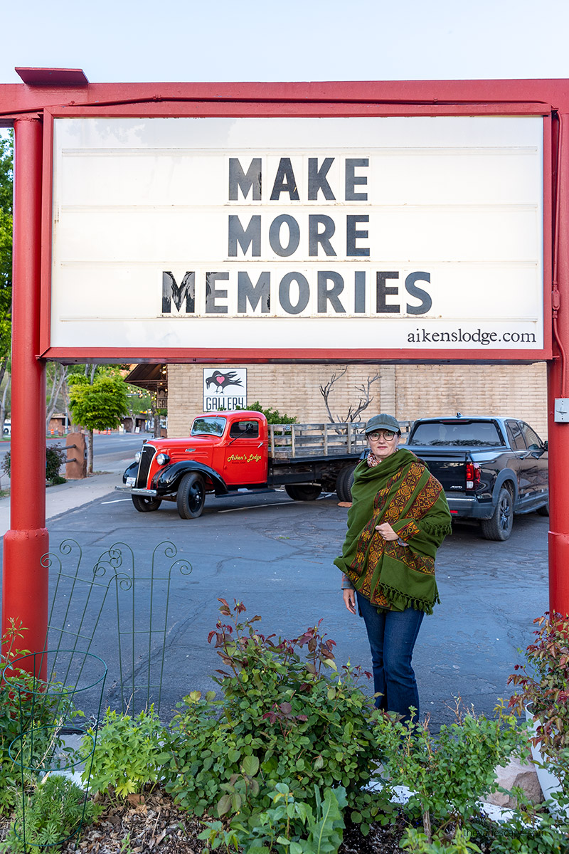 Agnes Stabinska, the author, in Kanab with the sign: make more memoris at aikens lodge