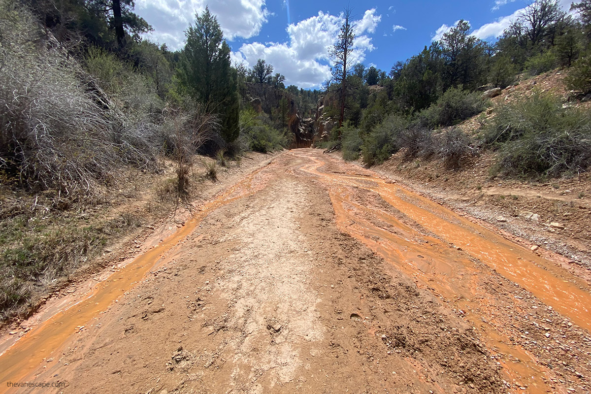 the wide riverbed with a small amount of water with a yellow tint before entering the slot canyon