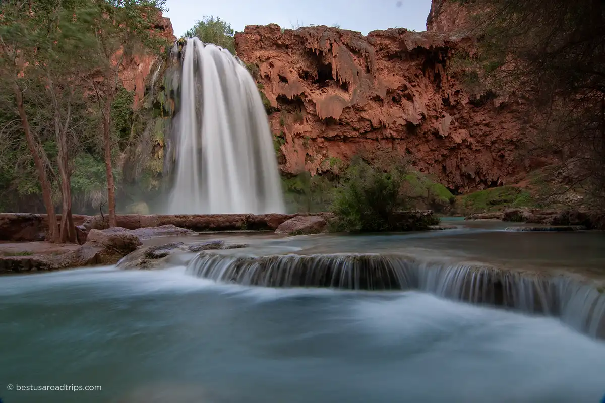 Havasu Falls - deep blue water and dark orange cliff walls.