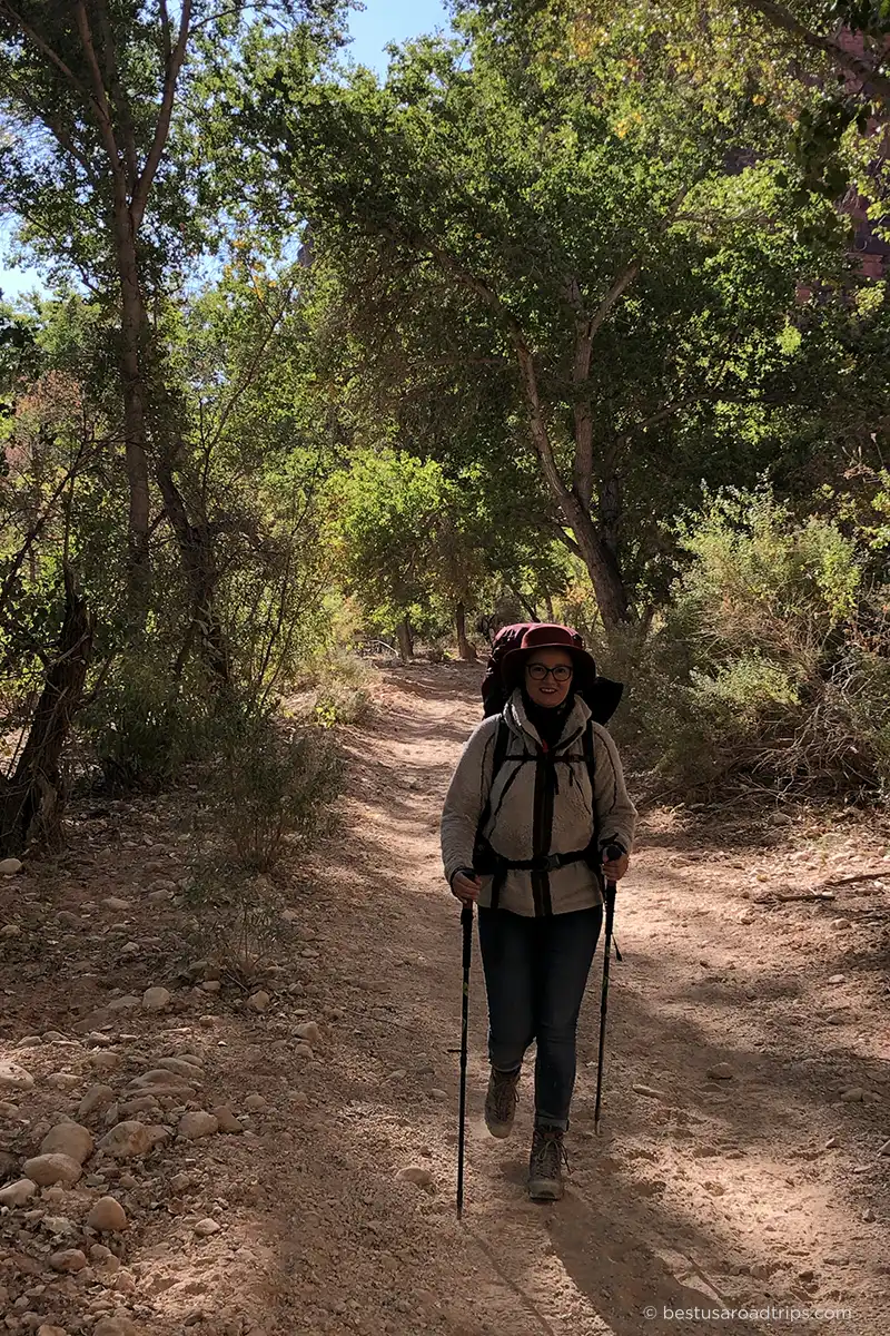 Agnes Stabinska on an early morning hike to Havasupai, wearing a backpack, fleece jacket, trekking poles, jeans, and hiking boots.