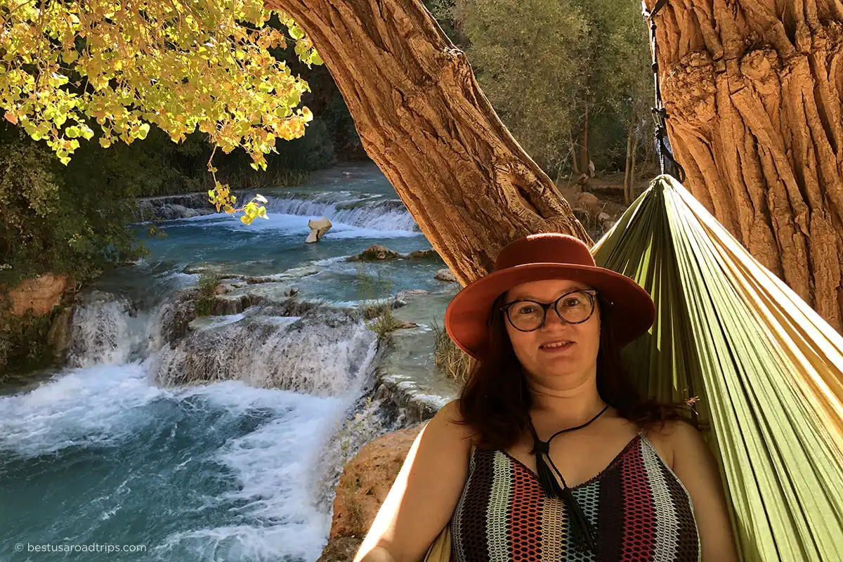 Agnes Stabinska crossing Havasu Creek on a wooden walkway during a chilly morning, wearing hiking boots and a fleece jacket.